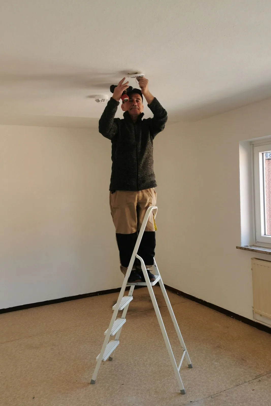 Fitting a ceiling detector from a step ladder, for ceiling fan installation in Salt Lake City