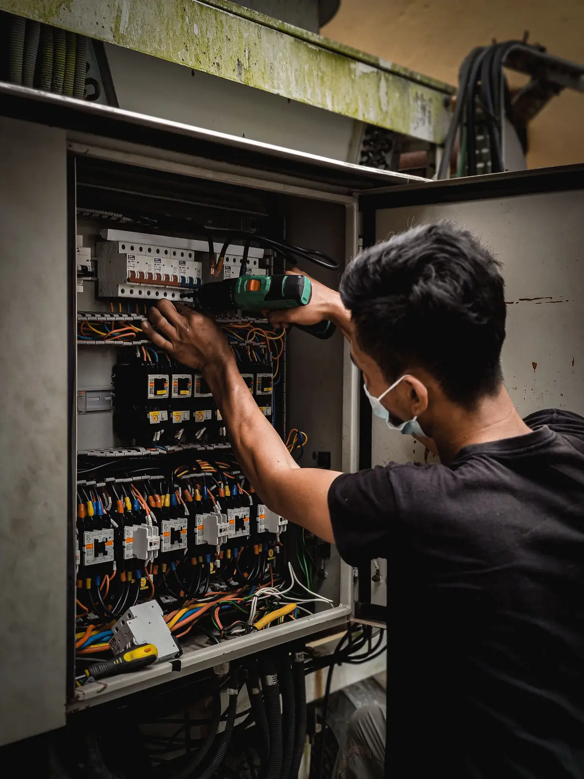 An electrician working inside a large distribution board, for commercial electrical in Salt Lake City