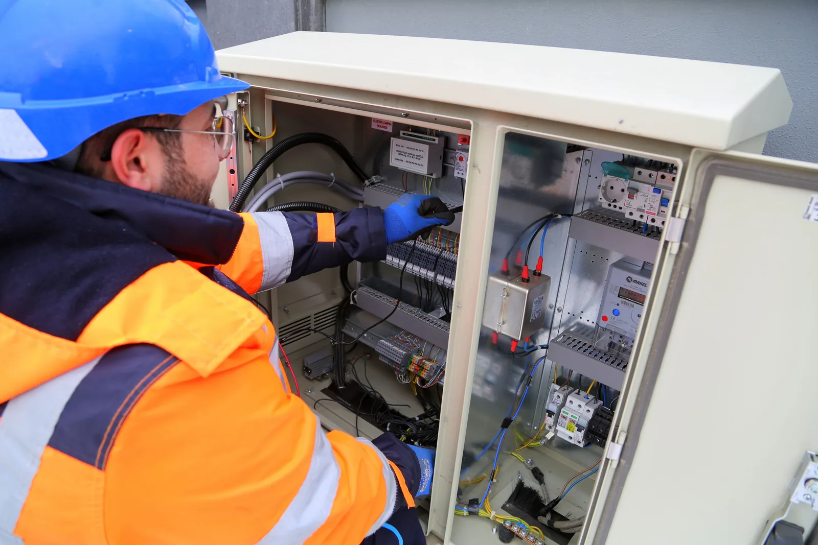 An electrician working in an outdoor service cabinet, for outdoor lighting in Salt Lake City